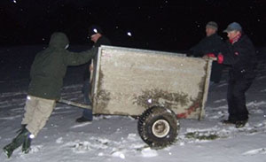 men moving equipment in snow